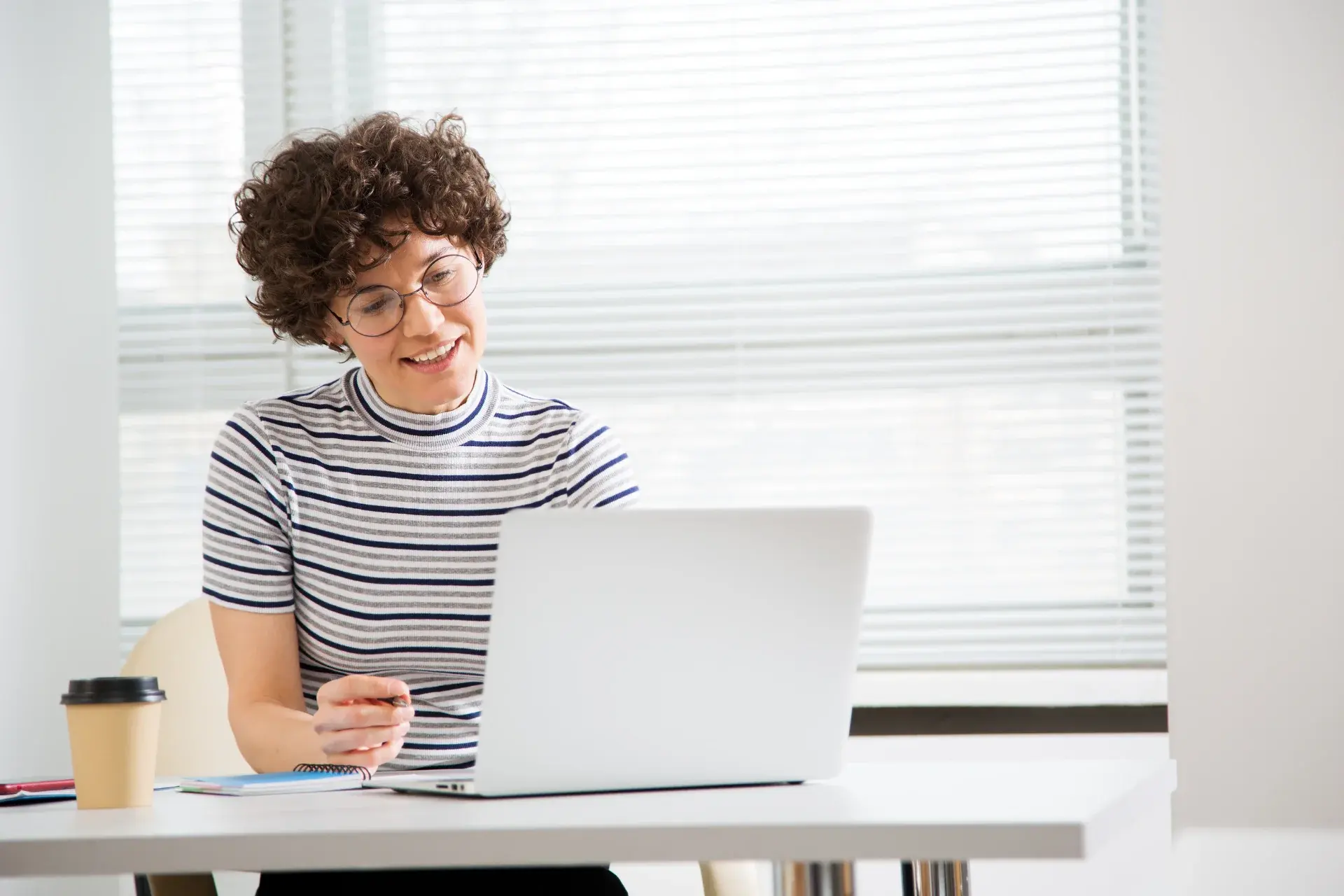 Bookkeeper working at a bright desk on a laptop, completing a monthly close